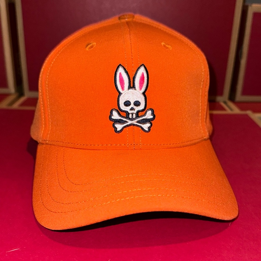 Orange psycho bunny strap back hat.